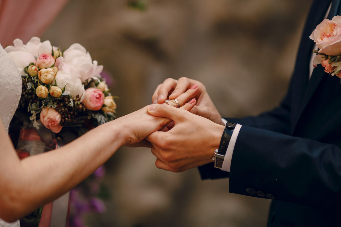 Un marié passe l’alliance au doigt de sa femme lors de leur cérémonie de mariage.